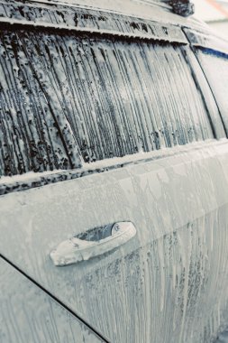 Bu görüntü, köpükle kaplı bir aracın yıkandığını gösteriyor. Sabunlu dokusunu ön plana çıkarıyor ve bu sürecin arabaların temizliğini ve parlaklığını nasıl artırdığını gösteriyor.