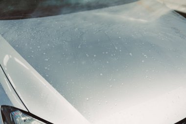 Parlak gümüş renkli bir araba kaputu, sayısız küçük su damlacıklarıyla parıldıyor. Yeni yıkanmış parlaklığını, zarafetini ve estetik görünümünü yeni bir güzellik seviyesine çıkarıyor.