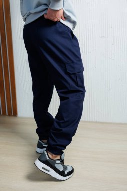 Şık bir donanma kargo pantolonu, siyah ve gri spor ayakkabıları ile zahmetsizce eşleştirilir, modern, modaya uygun ve rahat bir sokak stili sergilenir. Sıradan geziler için mükemmel görünür.