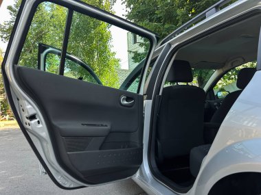 Modern otomotiv tasarımını keşfetmek için mükemmel, açık bir kapı, geniş bir oturma yeri ve hoş bir iç mekan gösteren çağdaş bir arabanın içine bir göz atmak..