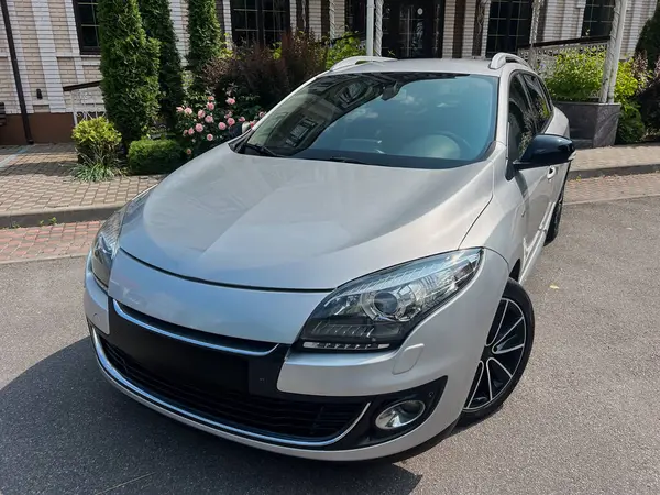 Çağdaş tasarımı olan şık gümüş renkli kompakt bir araba peyzajlı bir alana park edilmiş, şık alaşımlı tekerleklerini sergiliyor, şehir maceraları ve modern yaşam tarzları için mükemmel.