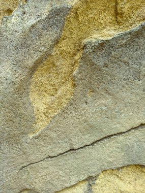 Benzersiz doğal desenler ve toprak renkler gösteren, doğa temalı projeler ve jeolojik çalışmalar için ideal bir kaya yüzeyinin yakın plan görüntüsü..