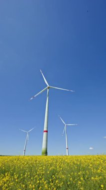 Yel değirmenleri, Avrupa 'nın kırsal bölgelerinde enerji üreten büyük türbinlerdir. Bir tarlada yel değirmenleri tarafından eko-enerji üretimi. Büyük yel değirmenleri olan bir arazi..