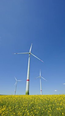 Enerji üreten yel değirmenleri olan yeşil alan. Rüzgar türbinleri alanda durur ve eko-enerji üretir. Avrupa 'da bir yerlerde yel değirmenleri.