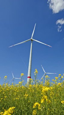 Yel değirmenleri, Avrupa 'nın kırsal bölgelerinde enerji üreten büyük türbinlerdir. Bir tarlada yel değirmenleri tarafından eko-enerji üretimi. Büyük yel değirmenleri olan bir arazi..