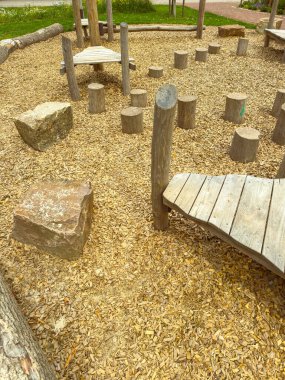 Ahşap kütükler, pürüzsüz taşlar ve çocuklar için aktif oyun ve yaratıcı keşifler için yumuşak kumlu bir yüzey içeren eşsiz bir doğaya sahip oyun alanını keşfedin.