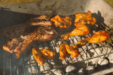 Izgara tavuk kanadı, but ve kömür mangalında leziz pirzola karışımı yaz barbekülerinin ve lezzetli lezzetlerin özünü yakalıyor..