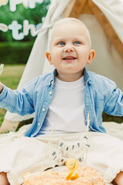 Neşeli bir bebek dışarıda ikinci doğum gününü renkli süslemeler, lezzetli bir pasta ve sevgi dolu aile ve arkadaşlar ile kutlar. Unutulmaz anılar yaratır.