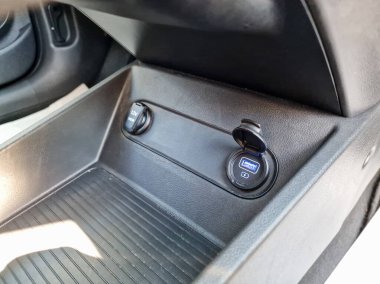 Bu modern görüntü, gelişmiş otomotiv tasarımı ve işlevselliğini ön plana çıkaran uygun bir USB portu ve aksesuar soketi olan şık bir araba tasarımı gösteriyor.