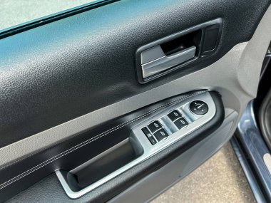 Bu kapsamlı ve detaylı manzarada, pencere kontrol paneli, kapı kolu ve çeşitli modern otomotiv tasarımı özellikleriyle bir araba kapısının içini gösteriyoruz.