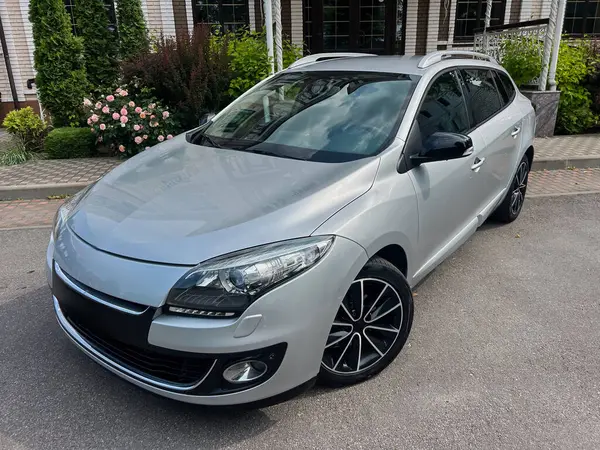 Canlı yeşilliklerle tamamlanmış, manzaralı bir yere park edilmiş şık gümüş hatchback araba. Araba meraklıları ve araba reklamları için mükemmel.