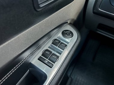 Pürüzsüz düğmelerini ve kaliteli otomotiv tasarımını ve ince iç özelliklerini yansıtan prim bitiş noktasını vurgulayan şık bir araba penceresi kontrol panelinin yakın çekimi