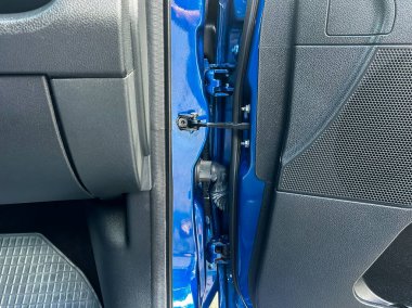 Bu resim, bir arabanın kapısının yakınındaki bileşenlerin yüksek çözünürlüklü bir yakın çekimini sunuyor, bir aracın içindeki karmaşık kabloları ve temel mekanik parçaları vurguluyor.