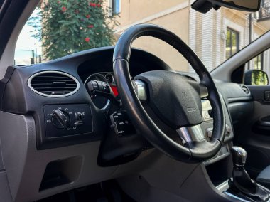 Bu iç görünüm zarif bir gösterge paneli, dokulu direksiyon ve kontrolleri vurgular, hepsi parlak bir ortamda, genel olarak keyifli sürüş deneyimini artırır