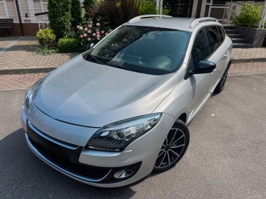 Modern, şık, gümüş renkli bir hatchback, canlı bir kentsel çevre içinde çekici bir şekilde konumlandırılmıştır. Şık tasarımı ve şehir sürüşü için mükemmel spor özellikleri sergilenmektedir.