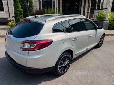 Güzel ve şık bir gümüş steyşın vagon, modern tasarımı ve parlak çizgileriyle sergilenen, pitoresk kentsel bir ortamda park halindedir.