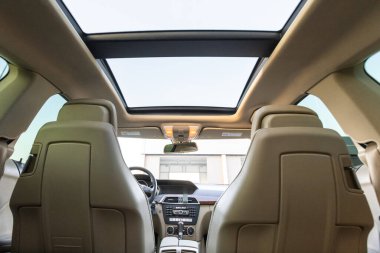Modern bir otomobilin içine girin ve konfor için geniş deri koltukları ve geniş gökyüzü manzaraları sunan çarpıcı bir sunroof ile lüks iç mekanını keşfedin.