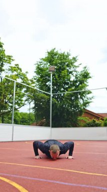 Genç atletik adam spor sahasında antrenman yapıyor ve egzersiz yapıyor. Formda kalmak için günlük egzersizler. Fitness sokağı antrenmanı. Halk spor salonunda kaslar. Güç, motivasyon. Açık spor salonu..