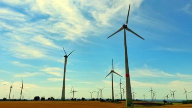 Mavi gökyüzüne karşı temiz enerji üreten rüzgar türbinlerinin çarpıcı manzarası sürdürülebilir teknolojiyi ve çevremizi gelecek için koruma ihtiyacını vurguluyor.