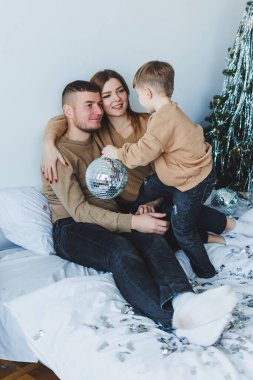 Sıcak, davetkar bir aile sahnesi. Ailelerin çocuklarıyla geçirdikleri sevgi ve sevinci gözler önüne seriyor. Hepsi de canlı şenlik dekorlarıyla çevrili.