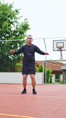 Açık hava basketbol sahasında şınav ve çömelmelerle dolu bir fitness seansına katılın. Atletizm eğitimi ve genel sağlık ve zindeliğin artırılması için idealdir.