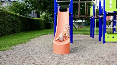 Neşeli çocuk oyun parkında kayıyor. Küçük çocuk şehir parkında oyun oynuyor. Çocuklar için plastik slaytlar. Çocuk parkındaki çocuklar için eğlence. Mutlu çocukluk.