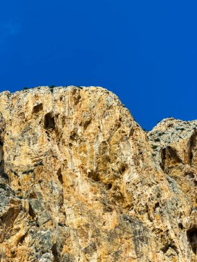 Kule gibi yükselen kayalar yeryüzüne hükmediyor. Engebeli yüzeyleri parlak güneş tarafından aydınlatılıyor. Parlak mavi gökyüzüne karşı batıyor ve doğanın ihtişamını yakalıyor..