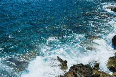Okyanusta parlak güneş ışığı parıldıyor dalgalar kayalık kıyılarda yuvarlanırken rahatlatıcı bir su ve taş ritmi yaratıyor. Mükemmel bir deniz kenarı sükuneti bizi çağırıyor..