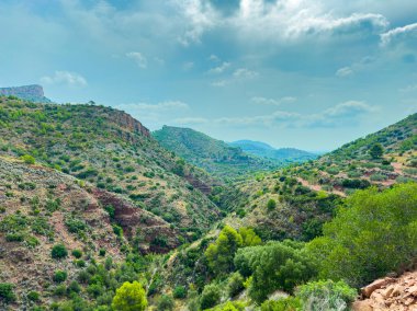 Bereketli tepeler yumuşak, bulutlu bir gökyüzünün altında yavaşça yuvarlanır. Uzağa uzanan huzurlu bir vadi canlı yeşillikler sergiliyor ve doğal güzellikleri davet ediyor. Açık hava maceraları için mükemmel..