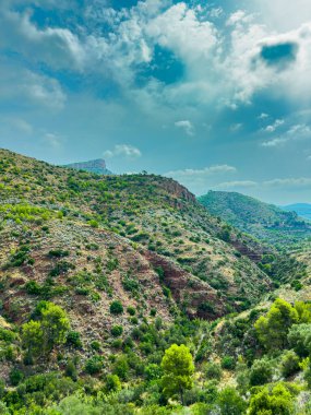 Canlı yeşilliklerle kaplı yuvarlanan tepeler kabarık bulutlarla kaplı parlak mavi bir gökyüzünün altında uzanıyor. Huzurlu vadi keşif ve sükuneti davet ediyor..