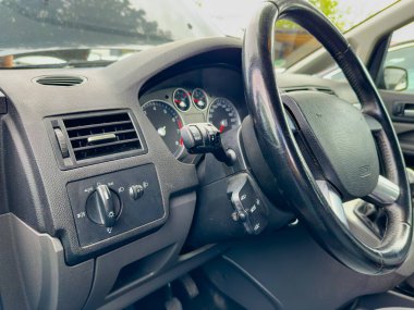 Bir aracın içinde, gösterge paneli gösterişli göstergeler ve kontroller gösterir. Direksiyon ve çeşitli düğmeler günlük seyahatin altını çizerek işlevsellik ve stilin bir karışımını oluşturur..