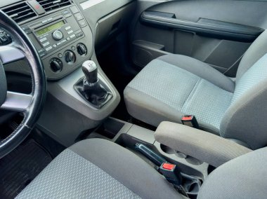 Çağdaş bir aracın içi gri kumaş koltuklu ergonomik bir tasarımı, temiz bir gösterge paneli ve hoş bir sürüş deneyimi için kullanıcı dostu kontrolleri ön plana çıkarıyor..