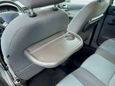 Katlanabilir bir masa ön koltuğun arkasına eklenir ve aperatifler, içecekler veya iş için pratik bir yüzey sunulur. Gri kumaş ve oturma yerleri yolcular için rahat bir atmosfer yaratıyor..