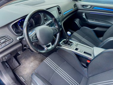 Sportif bir arabanın içinde modern gösterge paneli ve şık koltuklar göze çarpıyor. Parlak ışık, canlı iç mekanı güçlendiriyor ve sürüş için dinamik bir atmosfer yaratıyor..