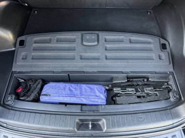 Temiz ve düzenli bir bagaj bölmesi araçlar, mavi bir çanta ve açık hava aktiviteleri ve yol gezileri için pratik depolama gösteren yumuşak bir nesne içerir..