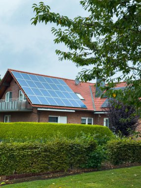 Güneş ışığı, büyüleyici bir eve yerleştirilmiş güneş panellerinden yansıyor. Canlı bir bahçeye yerleşmiş bulutlar yavaşça üstümüze doğru sürükleniyor. Huzurlu bir banliyö atmosferi yaratıyor..