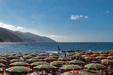 Monterosso 'da bir İtalyan plajında plaj şemsiyeleri.