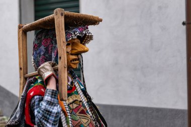 Shignano (Italy) 03/01/23: The carnival of Schignano parade is one of the most famous traditional carnivals of north Italy with typical wood masks and performer that entertain the visitors . clipart