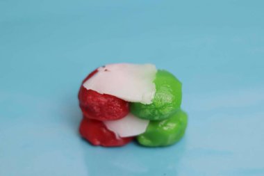 Hindistan ceviziyle dolu kırmızı ve yeşil market atıştırmalıkları. Mavi arka planda pazar atıştırmalıkları