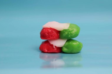 Hindistan ceviziyle dolu kırmızı ve yeşil market atıştırmalıkları. Mavi arka planda pazar atıştırmalıkları