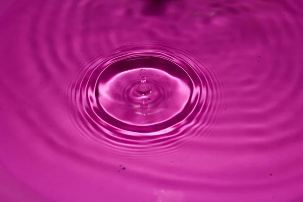 Pembe arka planda su damlası