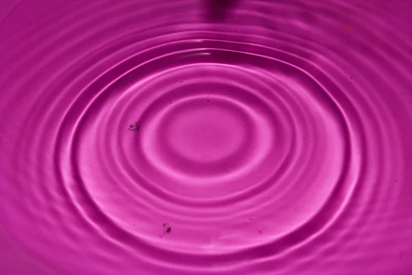 Pembe arka planda su damlası