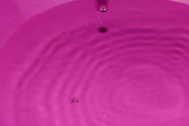 Pembe arka planda su damlası