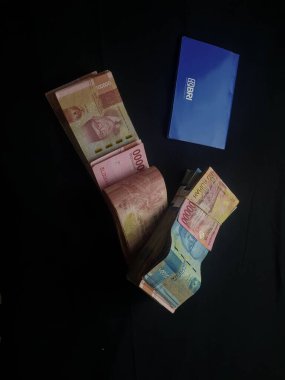 Güney Lampung, 03 Mart 2023; BRI Tasarruf Defteri ve Milyonlarca Rupiah siyah arka planda