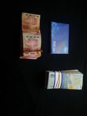 Güney Lampung, 03 Mart 2023; BRI Tasarruf Defteri ve Milyonlarca Rupiah siyah arka planda