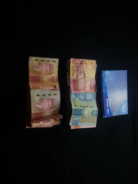 Güney Lampung, 03 Mart 2023; BRI Tasarruf Defteri ve Milyonlarca Rupiah siyah arka planda