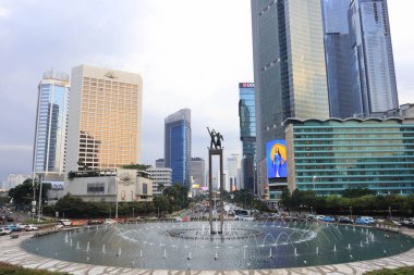 Jakarta, 19 Şubat 2023; Karşılama Anıtı, Endonezya Roundabout Oteli 'nin ortasında ellerinde çiçekler tutan ve el sallayan bir çift insanın heykeli.