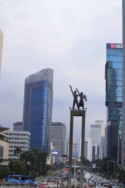 Jakarta, 19 Şubat 2023; Karşılama Anıtı, Endonezya Roundabout Oteli 'nin ortasında ellerinde çiçekler tutan ve el sallayan bir çift insanın heykeli.
