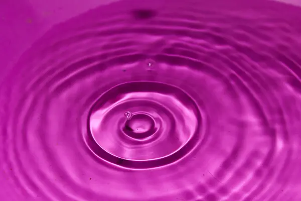 Water Druppel Een Roze Achtergrond — Stockfoto