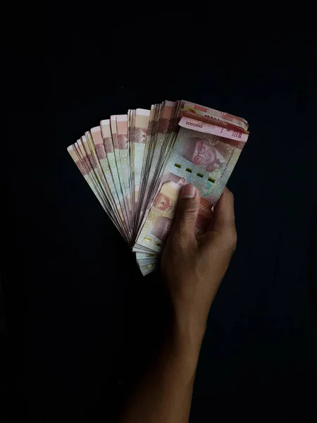 Uma Mão Masculina Segura Milhões Moedas Rupia Indonésia Fundo Preto — Fotografia de Stock